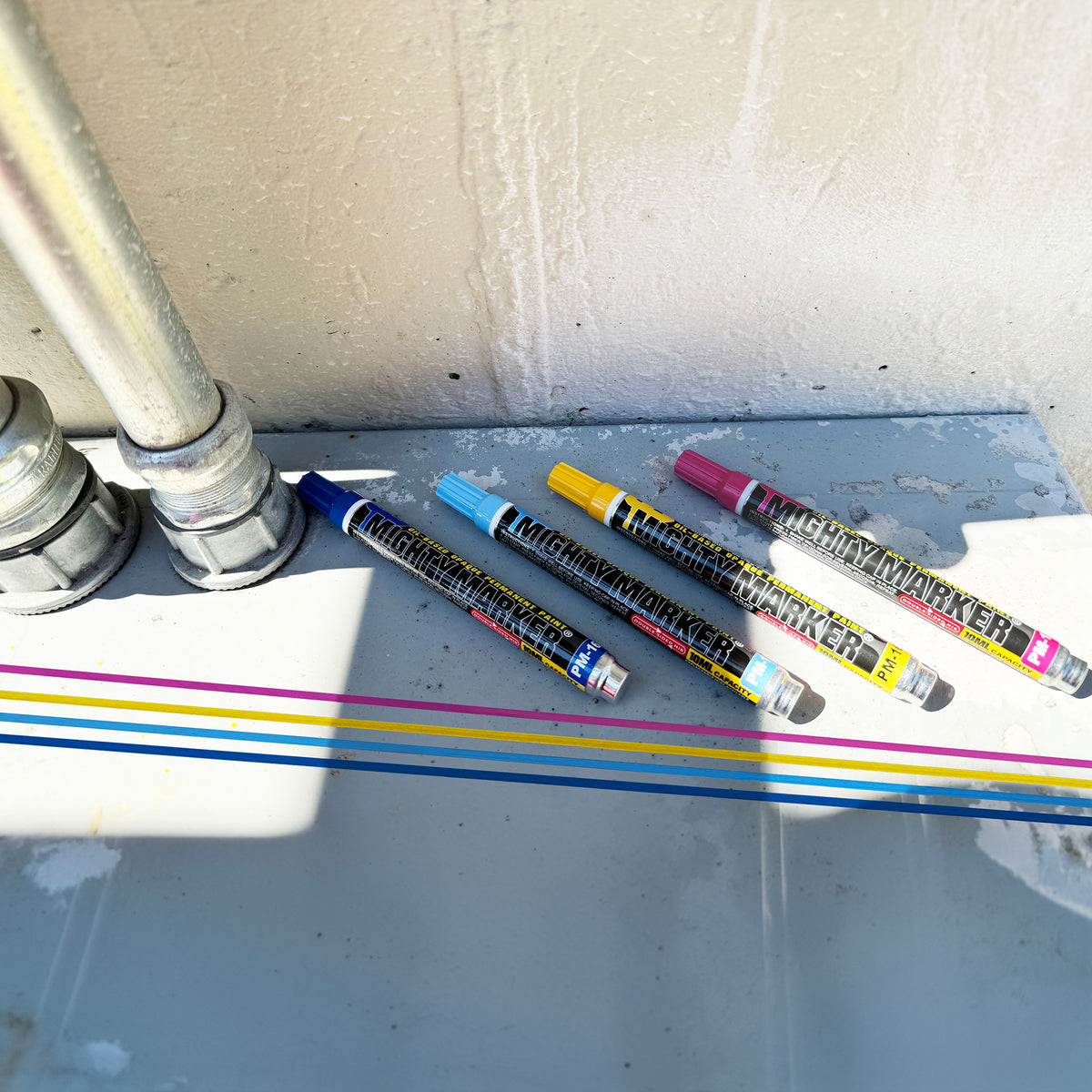 Four markers with colorful stripes on a white surface