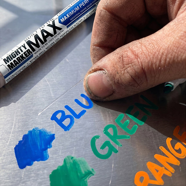 Blue, green, and orange paint marks on brushed metal