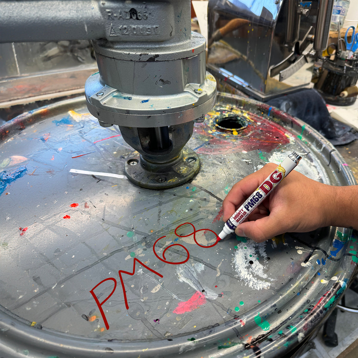 PM-68 red marking a metal barrel on a metallic surface with various colors and text in an industrial setting